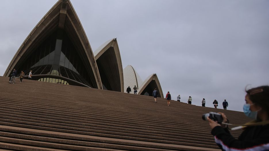 SYDNEY, AUSTRALIA - MARCH 14: A woman wearing a face mask as a preventative measure against Coronavirus COVID-19 takes photos in front of the Sydney Opera House in Sydney, Australia on March 14, 2020. Australia has recorded 200 coronavirus cases as Chief Medical Officer Brendan Murphy defended his advice to the federal cabinet after Minister for Home Affairs Peter Dutton contracted the virus. (Photo by Steven Saphore/Anadolu Agency via Getty Images)