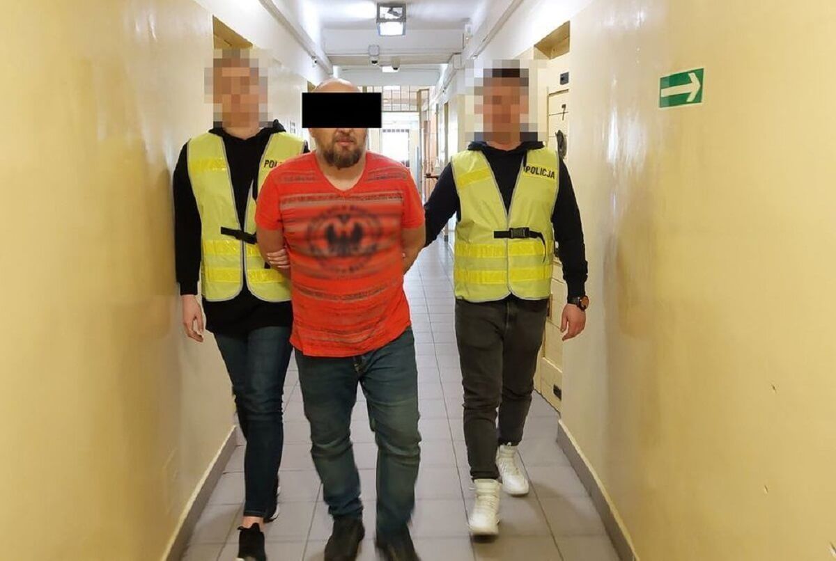 Policja prowadzi aresztowanego za groźby karalne