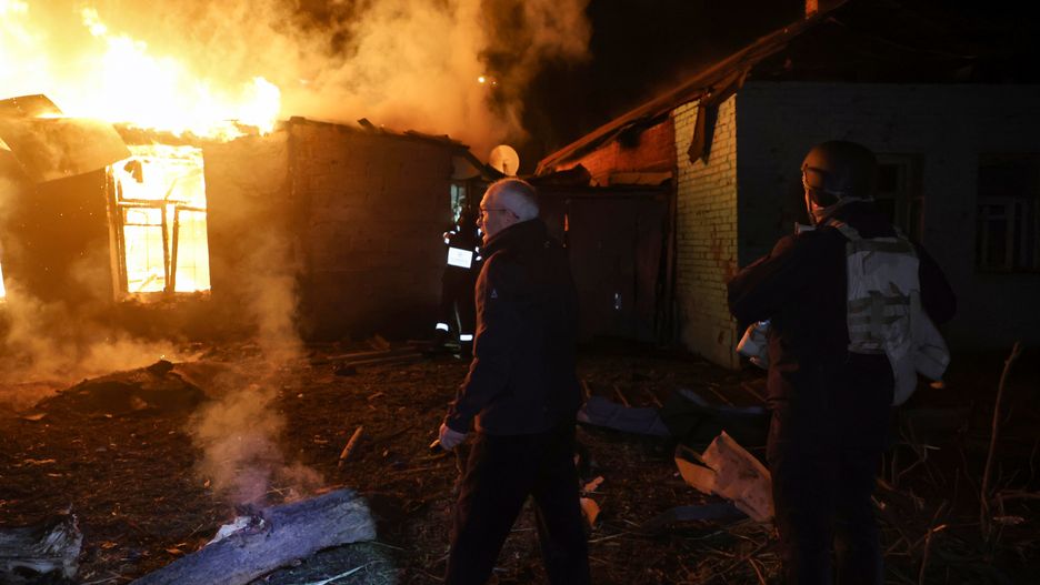 Onlookers watch a house burn during a response effort to a large-scale Russian drone attack in Kharkiv, Ukraine, on November 23, 2025. (Photo by Viacheslav Madiievskyi/Ukrinform/NurPhoto via Getty Images)