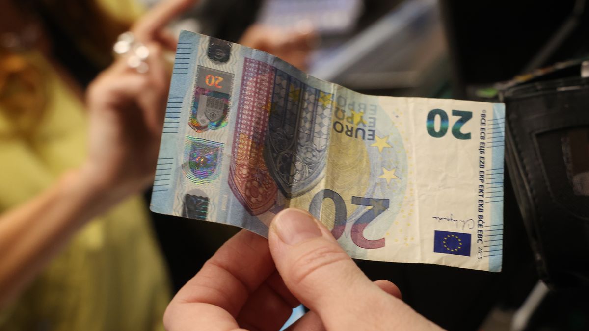 BERLIN, GERMANY - JANUARY 14: A shopper pays in cash with a 20 Euro bill for groceries during a promotional event at an Edeka supermarket on January 14, 2026 in Berlin, Germany. Edeka is among Germany's leading nationwide supermarket chains. (Photo by Sean Gallup/Getty Images)