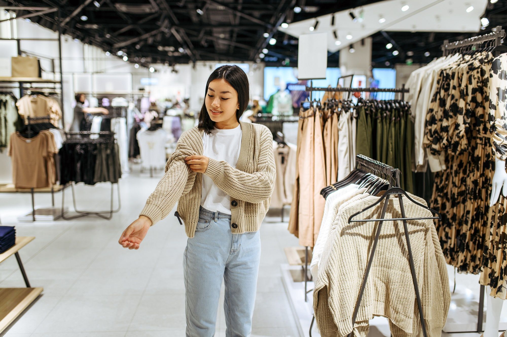 Young woman trying on cardigan in clothing storeYoung woman trying on cardigan in clothing store. Female person shopping in fashion boutique, shopaholic, shopper looking on garmentstore, sale, fashion, retail, clothes, customer, clothing, young, shopping, woman, shopper, mall, shop, lifestyle, dress, people, female, purchase, happy, boutique, pretty, beautiful, buy, smiling, girl, shopaholic, choice, hanger, consumerism, buyer, choosing, buying, attractive, choose, indoor, trying on, try on, person, fashionable, inside, garment, cheerful, client, center, lady, discount, style, wear, elegant, store, sale, fashion, retail, clothes, customer, clothing, young, shopping, woman, shopper, mall, shop, lifestyle, dress, people, female, purchase, happy, boutique, pretty, beautiful, buy, smiling, girl, shopaholic, choice, hanger, consumerism, buyer, choosing, buying, attractive, choose, indoor, trying on, try on, person, fashionable, inside, garment, cheerful, client, center, lady, discount, style, wear, elegant
