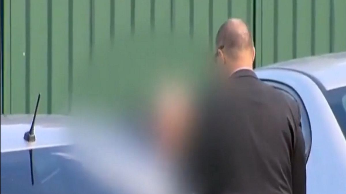 Były katolicki ksiądz zabierany przez policjantów przed sąd.
