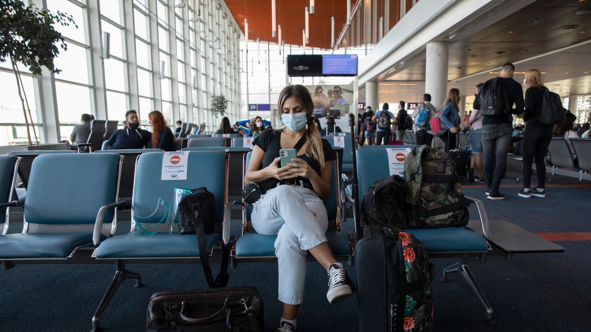 woman, airport, covid, covid19, pandemic, waiting, people, coronavirus, mask, chinstrap, headscarf, travel, traveling, tourism, tourism in pandemic, sitting, suitcase, luggage, baggage, young, protection, social distancing, transport, transportation, passenger, female, caucasian, latin, covid-19, virus, flight, ezeiza, buenos aires, argentina, epidemic, departure, safety, lifestyle, corona, protective, phone, cellphone, traveler, person, protective mask, check in, smartphone, international, tourist