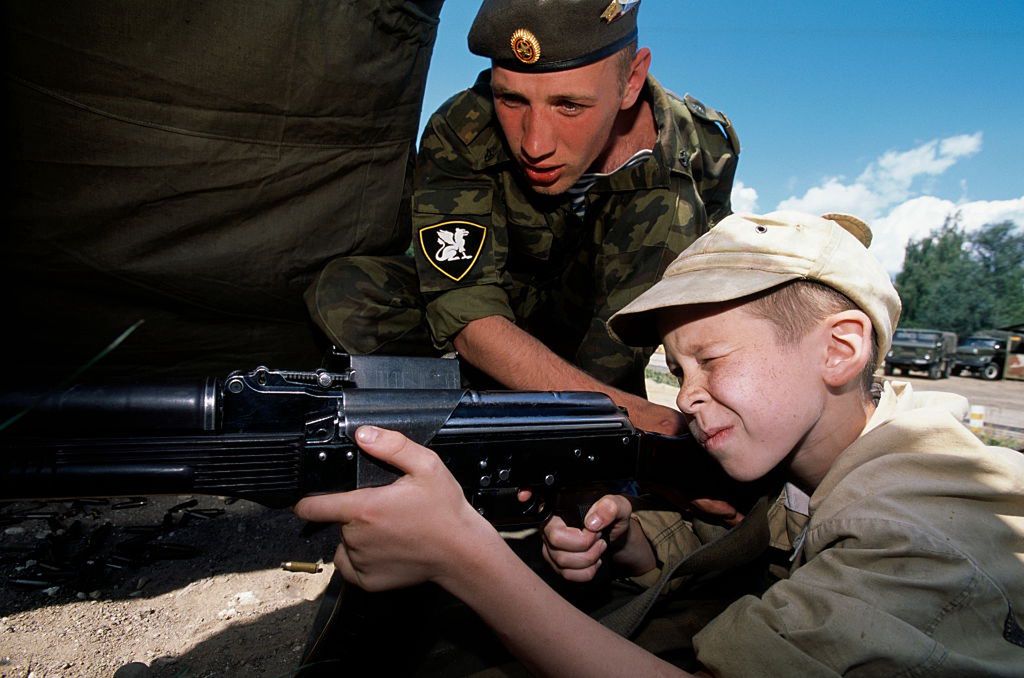 Russia - Kaskad Military Unit - Young cadet at the shooting rangeYoung 'cadet' during shooting exercises on a polygon of the 'inner army', some sort of military police in charge of securing state buildings, keeping peace and order during demonstrations, mass-meetings, and similar. At the shooting polygon each of the kids gets a frame of live ammunition and can choose to shoot with a light machine gun or with an assault rifle, the AK-74.  In 1982, facing mounting casualties among inexperienced conscripts in Afghanistan, an experimental military unit (Kaskad) was set up where young troops were learning survival skills, shootings, and-to-hand combat. The war in Afghanistan is over but Kaskad still exists and many other camps have mushroomed. Since 1982, 8000 children have passed through Kaskad alone. (Photo by Arne Hodalic/Corbis via Getty Images)Arne Hodalicchild:CB1, weapon:CB1, summer camp:CB1, cadet:CB1, commando:CB1, forest:CB2, soldier:CB1, special forces:CB1, summer:CB1, teenager:CB1, recruit:CB1, Zhukovsky:CB2, Soviet Union:CB1, instructor:CB1, shooting:CB1, training:CB1