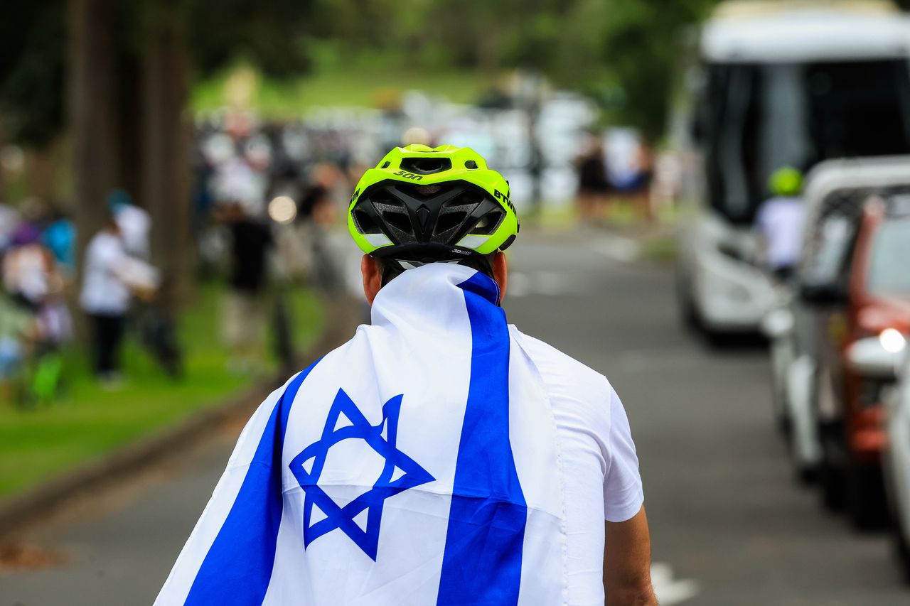  A cyclist wearing the flag of Israel