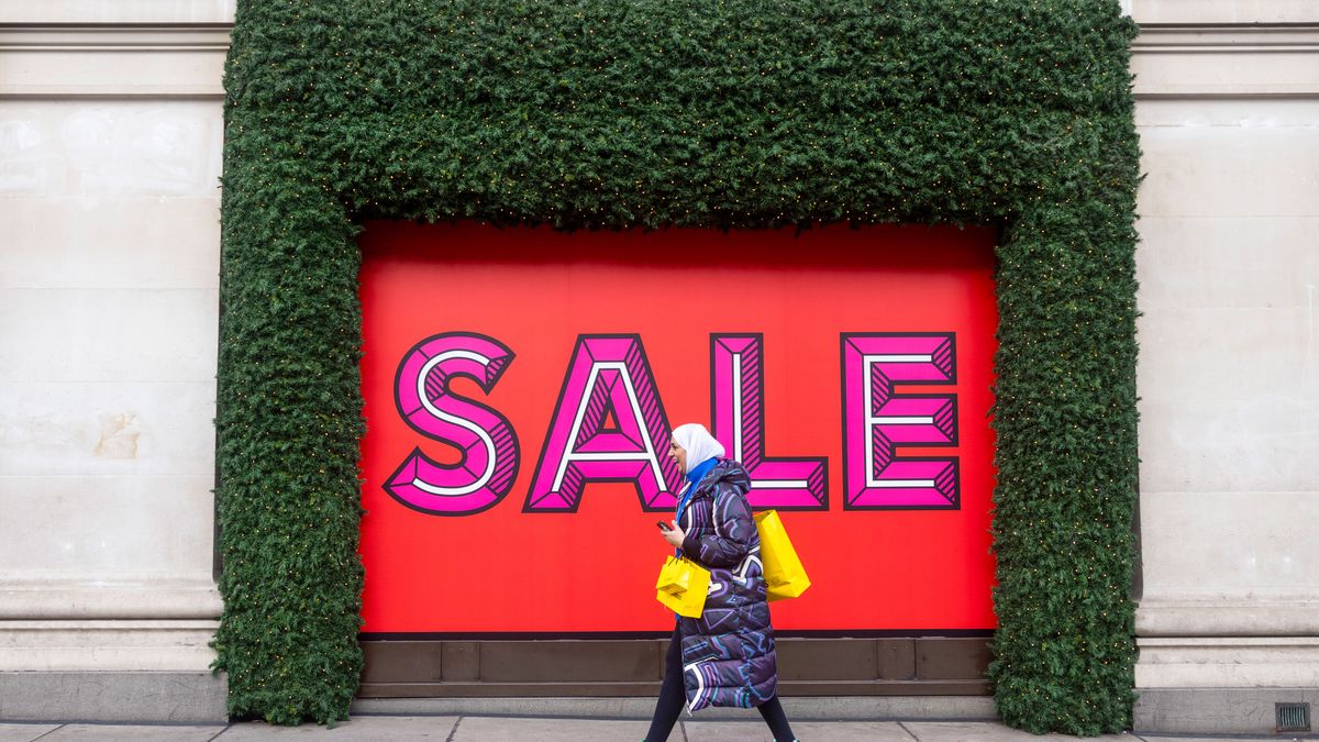 A shopper passes sale promotion signage at the Selfridges & Co. department store during traditional Boxing Day holiday sales, in London UK, on Tuesday, Dec. 26, 2023. The UK will be Europe's best-performing major economy in the next 15 years, narrowing the gap with Germany and extending its lead over France, according to new long-run forecasts. Photographer: Carlos Jasso/Bloomberg via Getty Images
