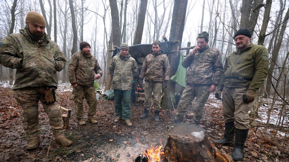 Soldiers of the 211th Pontoon Bridge Brigade of the Support Forces of the Armed Forces of Ukraine warm themselves by the fire as they build fortifications in the Kharkiv sector in the Kharkiv region, northeastern Ukraine, on December 11, 2024. (Photo by Ukrinform/NurPhoto via Getty Images)
