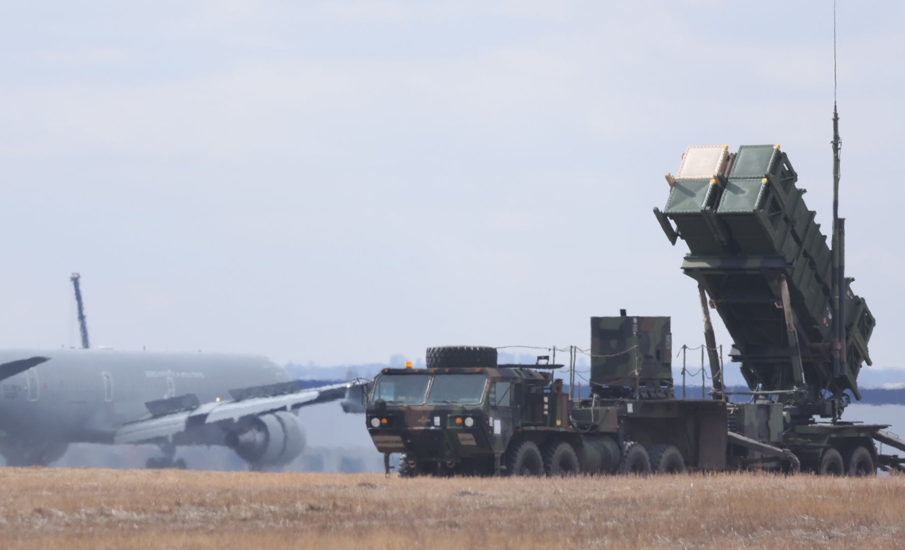 RZESZOW, POLAND - MARCH 08: An Italian military transport plane lands on the runway as a U.S. Army MIM-104 Patriot anti-missile defence launcher stands pointing east at Rzeszow Jasionska airport, an airport currently being used by the U.S. Army's 82nd Airborne Division, on March 8, 2022 near Rzeszow, Poland. NATO member countries have been flying military transport planes into Rzeszow on a regular basis recently following their announcements to supply Ukrainian armed forces with weapons. The U.S., in response to the Russian military buildup and subsequent invasion of Ukraine, and in concert with other NATO member states deploying additional troops across eastern European countries, has sent thousands of troops to southeastern Poland, where they have set up bases at Rzeszow and at least three smaller airfields, all not far from Poland's border to Ukraine. Meanwhile fighting between the Russian military and Ukrainian armed forces is continuing across Ukraine. (Photo by Sean Gallup/Getty Images)