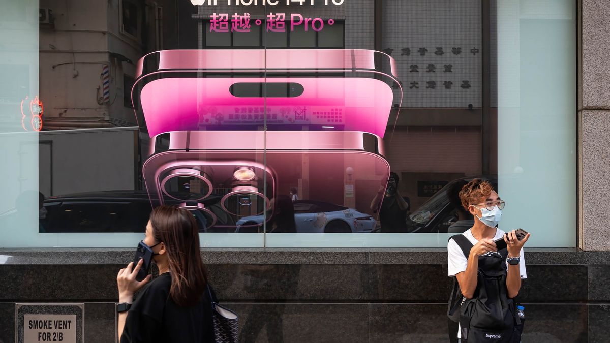 HONG KONG, CHINA - 2022/09/19: A pedestrian using a smartphone walks past an American multinational technology company, Apple iPhone 14 Pro advertisement in Hong Kong. (Photo by Sebastian Ng/SOPA Images/LightRocket via Getty Images)