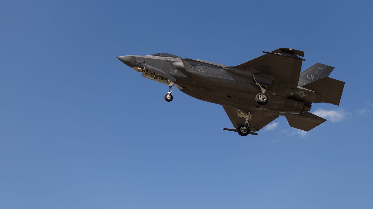LAKENHEATH, ENGLAND - APRIL 17: A US Air Force fifth generation F-35A Lightning II stealth aircraft comes in to land as protesters stage a peaceful demonstration outside RAF Lakenheath on April 17, 2025 in Lakenheath, England. From 1981, a group of women supporting the Campaign for Nuclear Disarmament (CND) held a peace camp at RAF Greenham Common, which eventually led to the removal of US nuclear weapons from the military base in 1988. Some of the same women are at the peace camp outside RAF Lakenheath today after reports that a secret deal with the United States has been struck to once again house American nuclear weapons on British soil.  (Photo by Dan Kitwood/Getty Images)