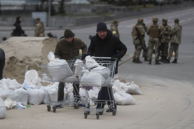 epa09805723 Ukrainian people prepare barriers made of sandbags in downtown Kyiv (Kiev), Ukraine, 06 March 2022. Russian troops entered Ukraine on 24 February leading to a massive exodus of Ukrainians as well as internal displacements. According to the United Nations (UN), at least 1.5 million people have fled Ukraine to neighboring countries since the beginning of Russia's invasion.  EPA/ZURAB KURTSIKIDZE Dostawca: PAP/EPA.