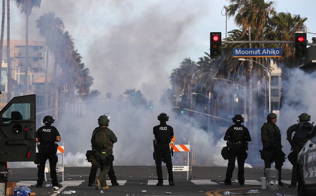 Santa Monica. Policjanci patrzą, jak roznosi się chmura gazu łzawiącego.
