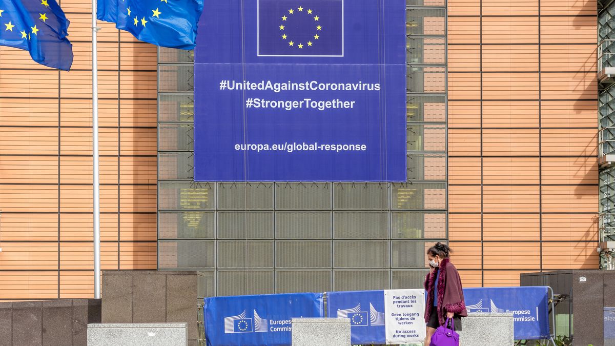A woman walk in front of the Berlaymont building  wearing a protective masks where the European Commission headquarters is in Brussels, Belgium 01 May 2020. New banner about the coronavirus global response, In order to contain the spread of Coronavirus ( COVID-19) globle response. (Photo by Jonathan Raa/NurPhoto via Getty Images)