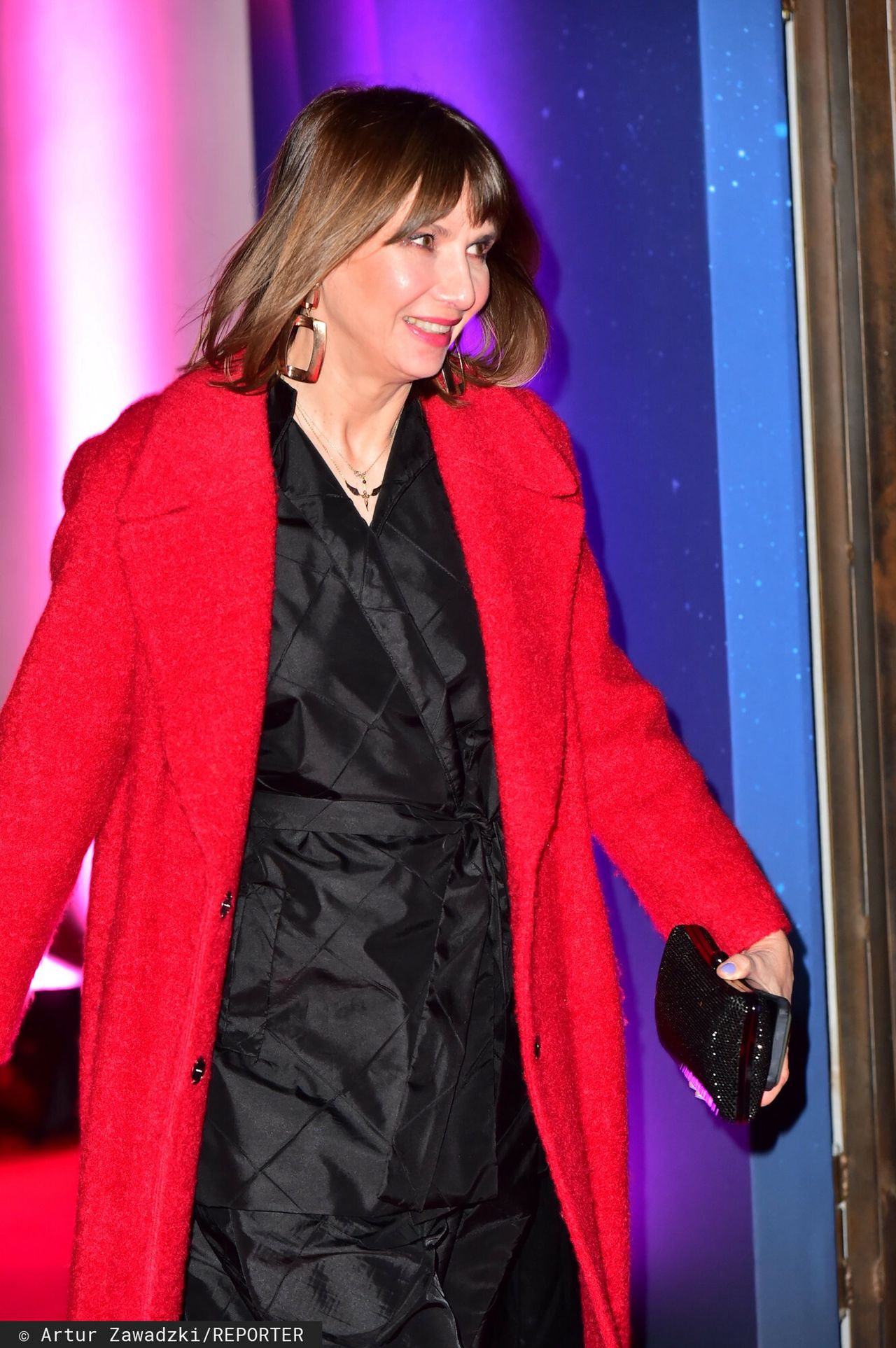 Grażyna Wolszczak w czarnym komplecie i czerwonym płaszczu 