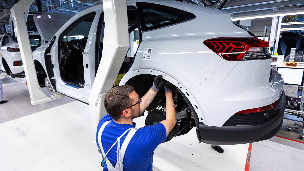 An employee works in the wheel arch of an Audi Q4 e-tron electric vehicle (EV) on the assembly line at the Volkswagen AG (VW) electric automobile plant in Zwickau, Germany, on Tuesday, April 26, 2022. The Zwickau assembly lines are the centerpiece of a plan by VW, the world's biggest automaker, to manufacture as many as 330,000 cars annually. Photographer: Krisztian Bocsi/Bloomberg via Getty Images