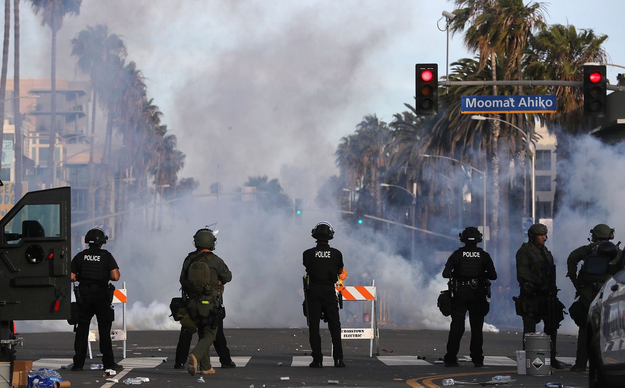 Santa Monica. Policjanci patrzą, jak roznosi się chmura gazu łzawiącego.