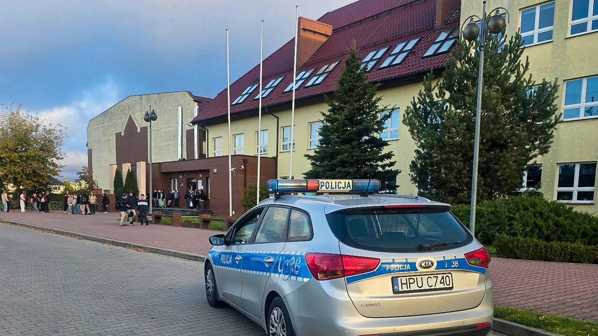 Radiowóz policji przed budynkiem szkoły w powiecie chodzieskim