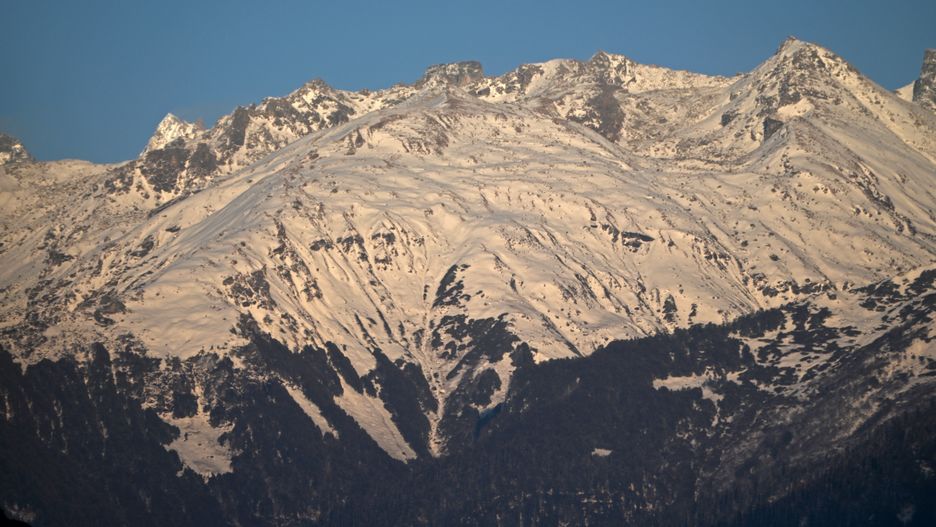 The snow-covered Himalayan mountain range is seen during sunset in Fojal Valley in Kullu district, Himachal Pradesh, India, on December 29, 2024. (Photo by Indranil Aditya/NurPhoto via Getty Images)