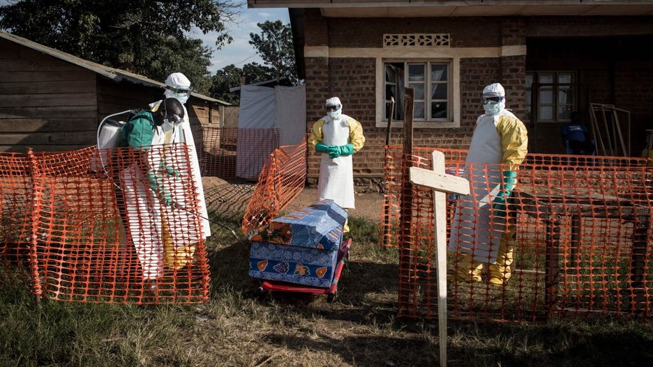 Pracownicy medyczni dezynfekują trumnę ofiary eboli