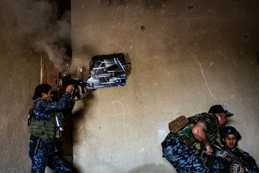 Pocisk wystrzelony przez bojowników ISIS przelatuje obok irakijskiego policjanta.