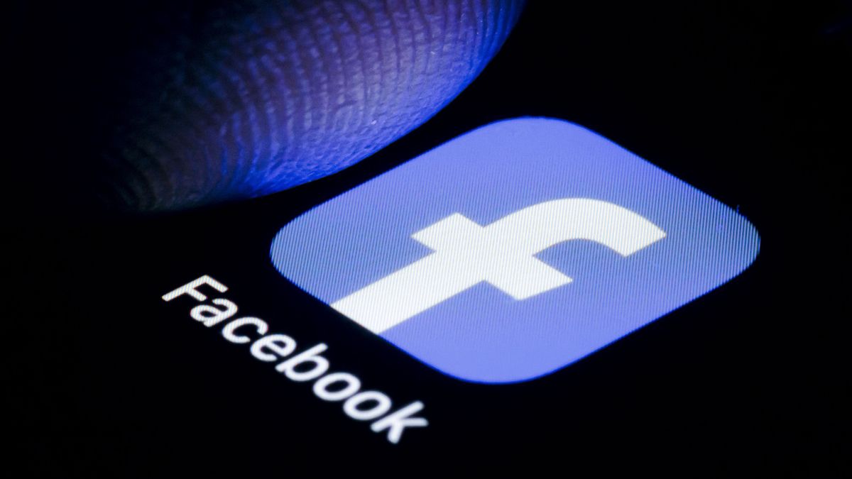 BERLIN, GERMANY - OCTOBER 06: In this photo illustration the Logo of Facebook App is illuminated on a smartphone close to a finger on October 06, 2023 in Berlin, Germany. (Photo Illustration by Thomas Trutschel/Photothek via Getty Images)