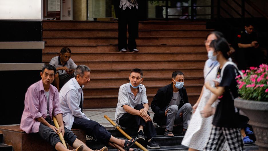 Porters sit at the Jiefangbei pedestrian street in Chongqing, China, 30 August 2022. Local authorities implemented tighter COVID-19 restrictions after 11 cases were detected in Chongqing, by imposing mass testing and establishing temporary control areas. EPA/WU HAO Dostawca: PAP/EPA.