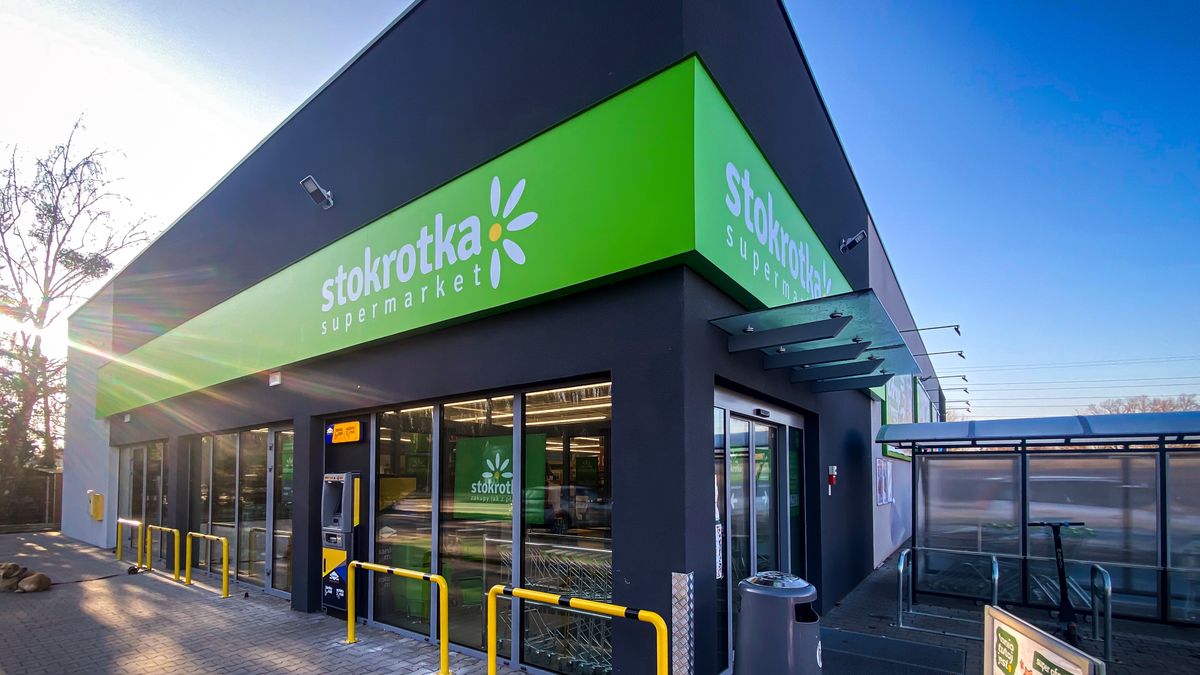 sklep, stokrotka, fasada, logo, supermarket, sklep spożywczy, detaliczny, witryna, zakupy, parking przed sklepem, logo firmy, marketing, sklep stacjonarny, sprzedaż, asortyment, front, budynek, zakupy spożywcze, otwarte drzwi, podmiejski