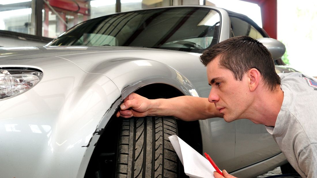 Zdjęcie mężczyzny oceniającej skutki kolizji