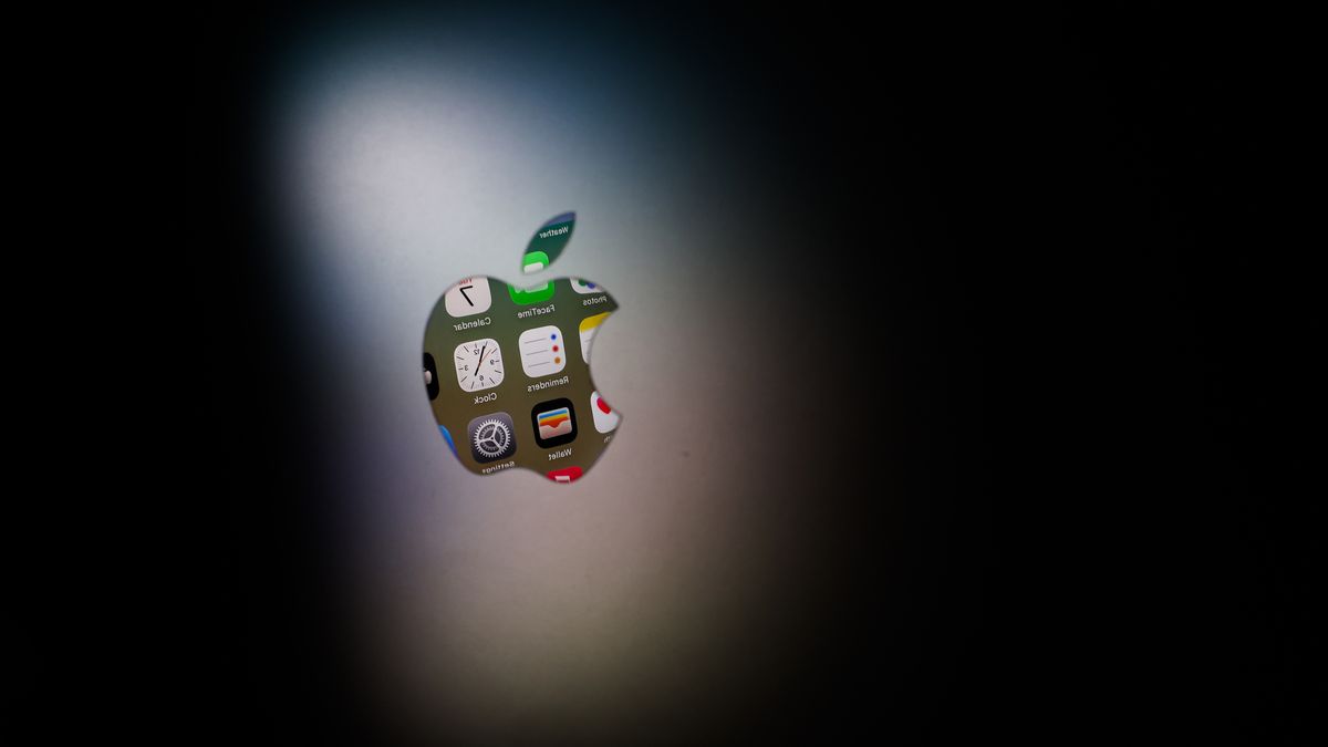 Icons displayed on iPhone screen are seen reflected in Apple logo on MacBook  in this illustration photo taken in Krakow, Poland on October 7, 2025. (Photo by Jakub Porzycki/NurPhoto via Getty Images)