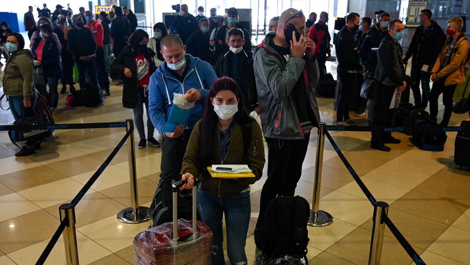 TemporaryUkrainian seasonal workers wearing face mask wait in line to check in to a flight to Finland at Boryspil airport in Kiev on May 13, 2020. - In an almost empty terminal at Boryspil airport in Kiev, Yuriy was waiting in a busy line of 200 seasonal workers to check in to a lone flight to Finland. The flight was an exception after Ukraine closed its borders and grounded air travel in March to contain the coronavirus, stranding Ukrainian labourers who would usually be harvesting crops on farms throughout Europe. Faced with the prospect of fruits and vegetables rotting in fields, farmers in countries including the United Kingdom and Finland moved to solve the problem by chartering flights for workers. (Photo by GENYA SAVILOV / AFP)GENYA SAVILOV