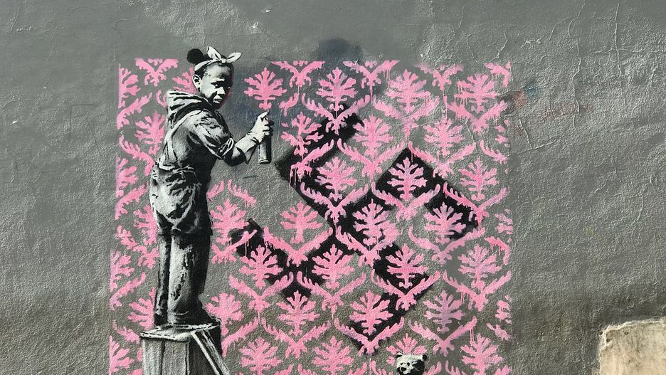 Banksy maluje polityczne murale w Paryżu. Na tym dziewczynka zasłania swastykę