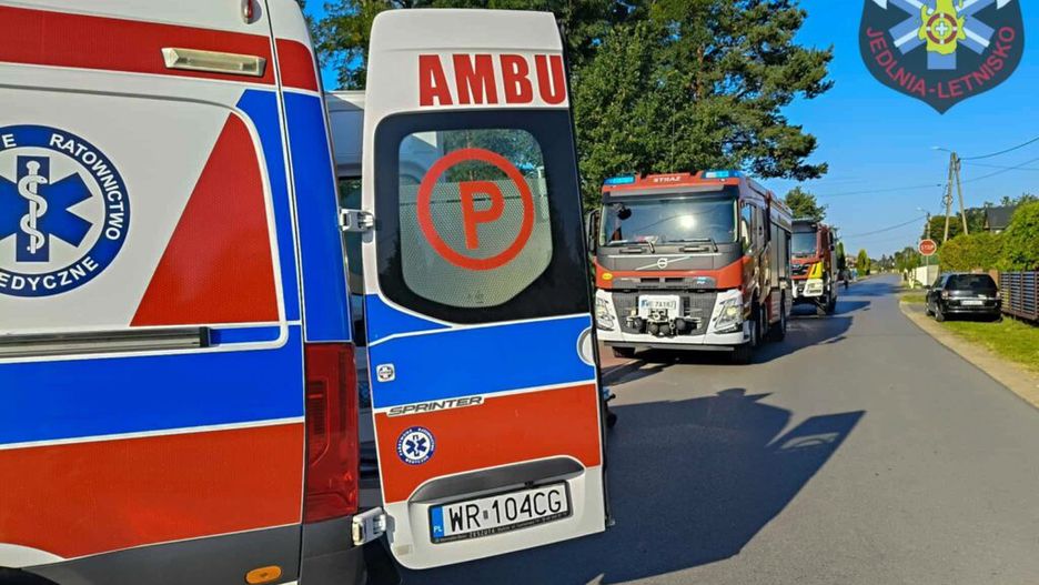 Karetka pogotowia oraz dwa wozy strażackie zaparkowane na ulicy w spokojnej okolicy.