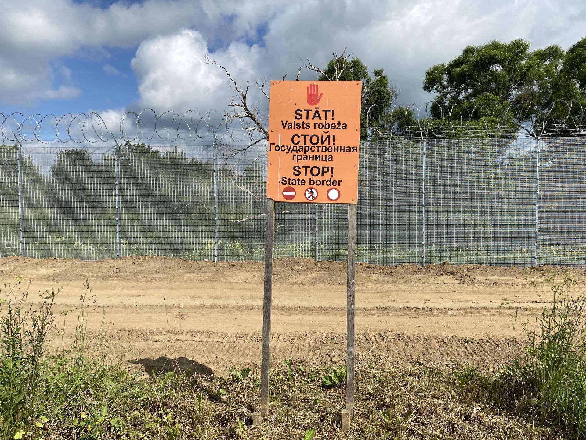 Tabliczka z napisem "Stop - granica państwa" w trzech językach
