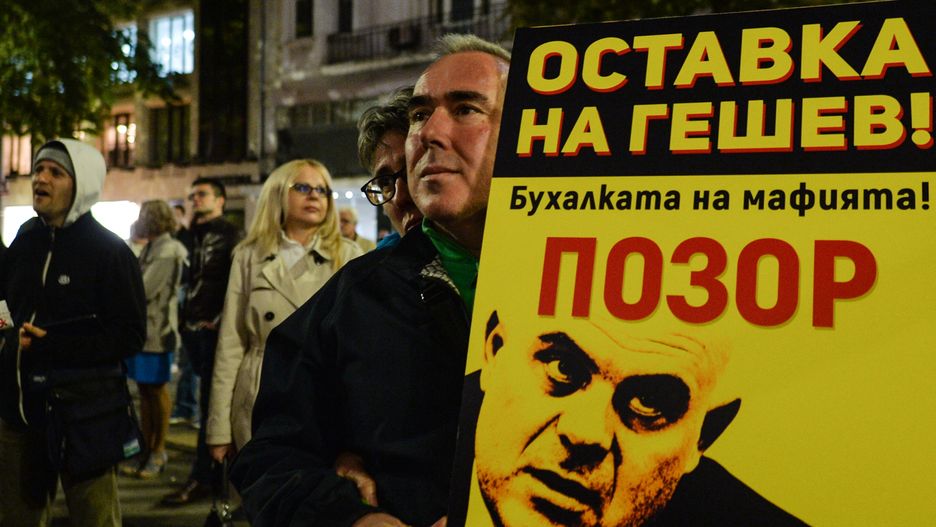 Uczestnik demonstracji przeciwko korupcji władzy w Bułgarii trzyma w ręku portret niechcianego prokuratora Iwana Geszewa
