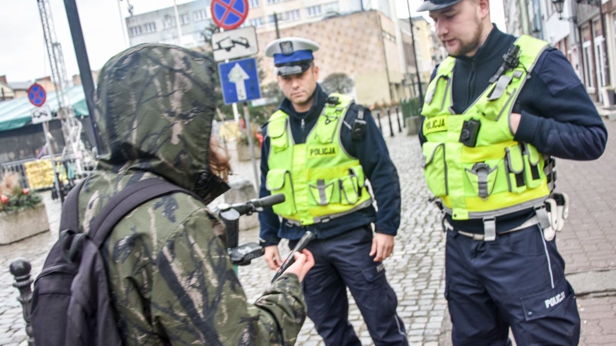 Policja i pieszy używający telefonu na przejściu