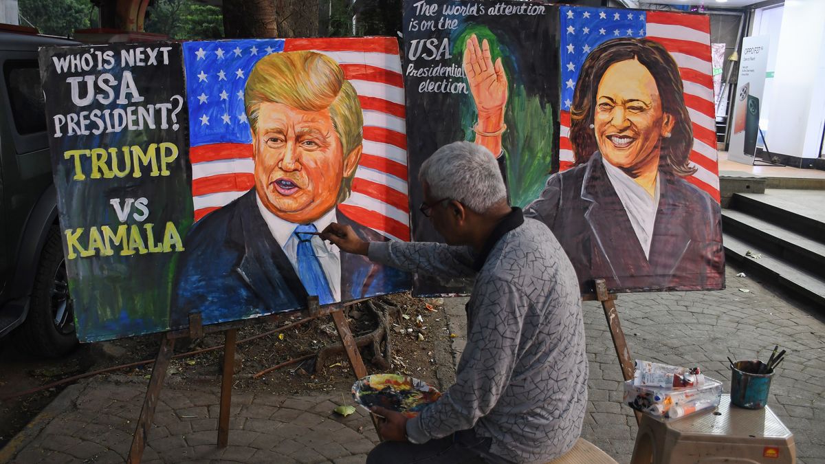 MUMBAI, MAHARASHTRA, INDIA - 2024/11/04: Teacher from Gurukul School of art paints a poster depicting U.S. presidential candidate Donald Trump and Kamala Harris, questioning who will win the upcoming presidential election in the United States, as they walk along the street outside the art school. The U.S. presidential election will take place on November 5, 2024. (Photo by Ashish Vaishnav/SOPA Images/LightRocket via Getty Images)