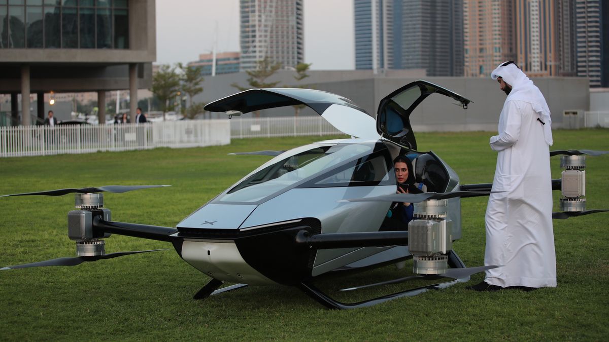 Emiratis inspect the eVTOL flying car X2 during the world-first public flight as part of the Gulf Information Technology Exhibition (GITEX) Global 2022 at the runway of SkyDive Dubai in the Gulf emirate of Dubai, United Arab Emirates, 10 October 2022. In partnership with the Dubai International Chamber, XPENG and EV manufacturer specialised in designing, developing, manufacturing, and marketing intelligent mobility solutions has chosen Dubai to be hosting exclusively the world-first public flight of its pioneering eVTOL flying car X2. EPA/ALI HAIDER Dostawca: PAP/EPA.