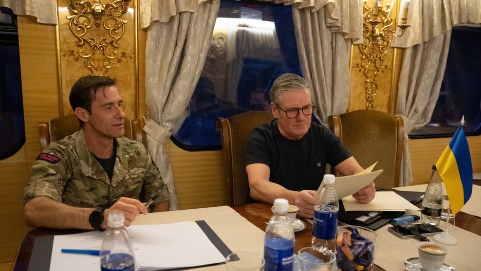 Prime Minister Sir Keir Starmer is briefed by his military assistant (name not given) on a train bound for Kyiv, as he visits Ukraine to sign a new long-term partnership deal with Volodymyr Zelensky. The 100 Year Partnership includes defence and scientific collaboration but will also forge new community links between the UK and Ukraine. Picture date: Thursday January 16, 2025. (Photo by Carl Court/PA Images via Getty Images)