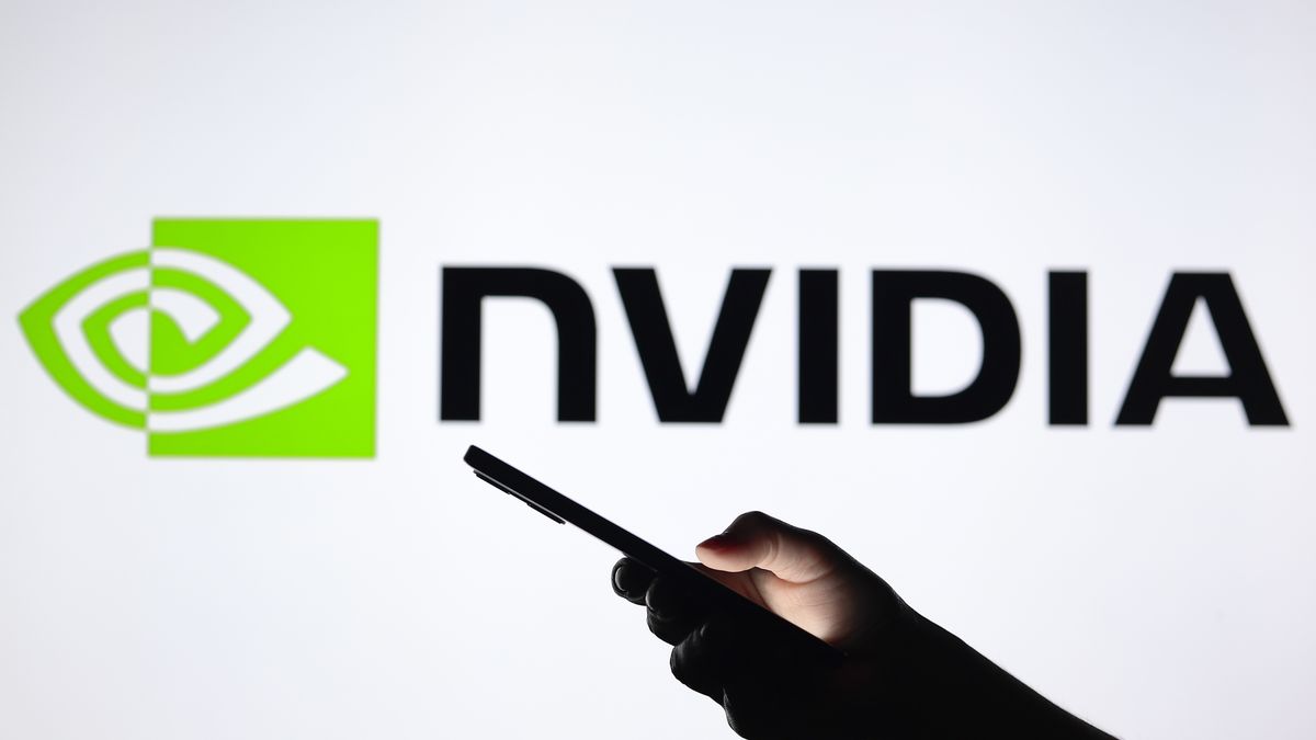 PARAGUAY - 2024/08/03: In this photo illustration, the Nvidia Corporation logo seen in the background with a silhouette hand holding a smartphone. (Photo Illustration by Jaque Silva/SOPA Images/LightRocket via Getty Images)