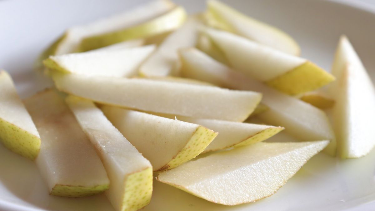 Whole and sliced/chopped Pear fruit in a white ceramic plate/Still lifeVeena Nair