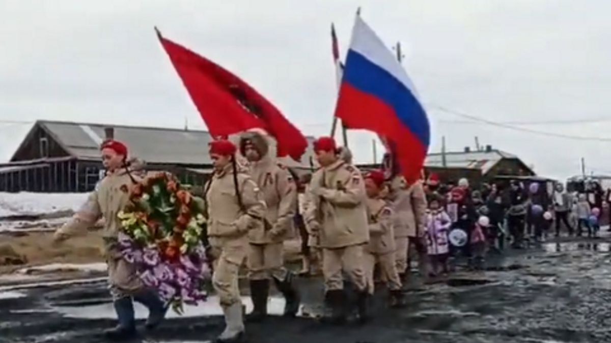 Marsz szedł przez szutrową drogę pełną kałuży
