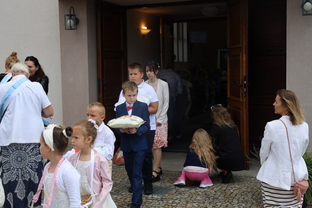 Procesja Bożego Ciała w Jankowie Dolnym. Dziewczynki z przejęciem sypały kolorowe kwiatki