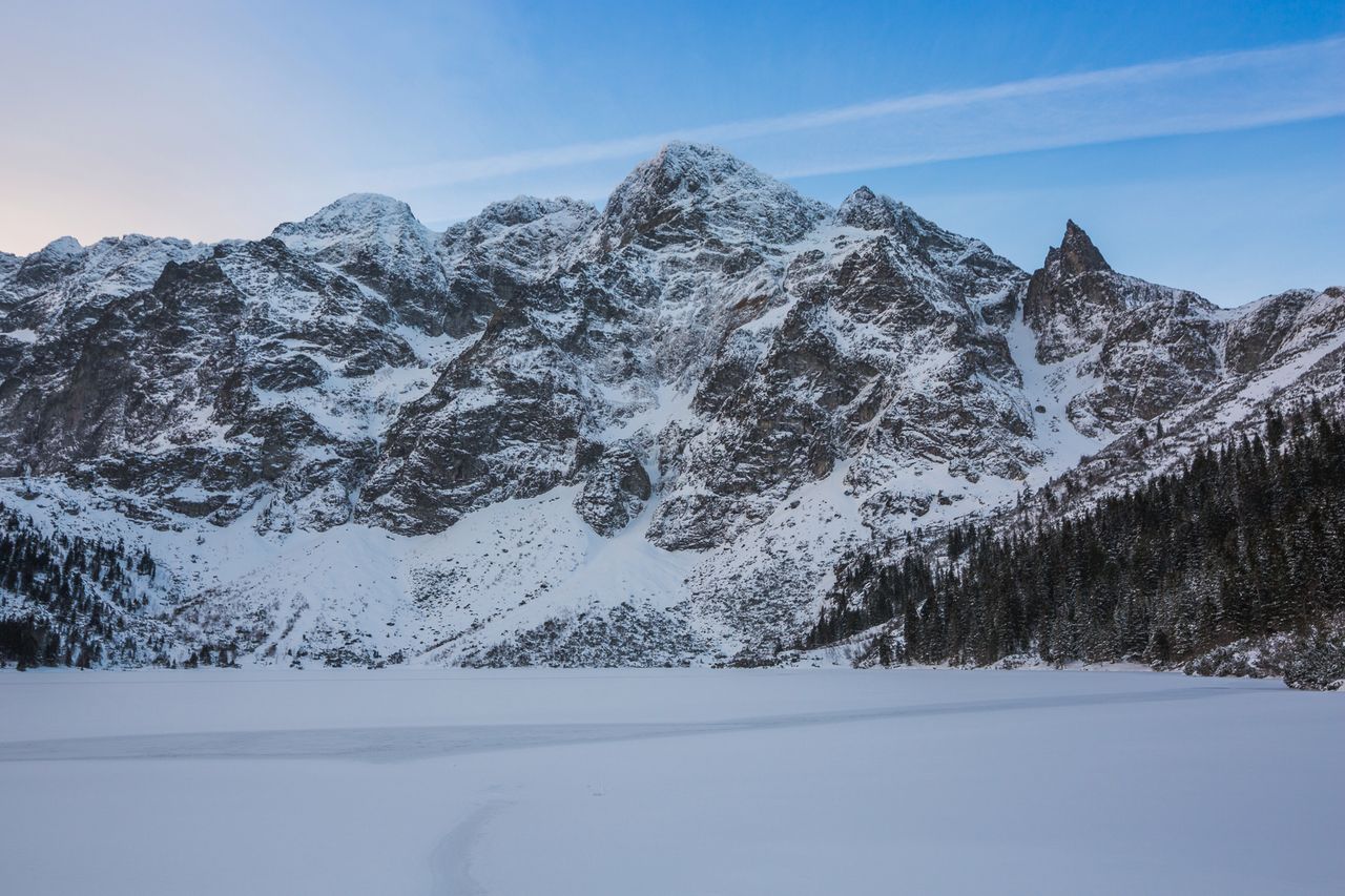 Canon 5D Mark III +  Tokina AT-X PRO FX SD 16-28 mm f/2.8 |  16 mm f/9, 1/80 s, ISO 250. Tatry, Morskie Oko. Dzięki dużemu polu widzenia obiektywu Tokiny, mogłem objąć zarówno tatrzańskie szczyty i zamarzniętą taflę Morskiego Oka. Kompozycyjnie jest to klasyczne ujęcie, za pomocą linii na śniegu oraz drzew  prowadzę wzrok widza do centrum kadru.