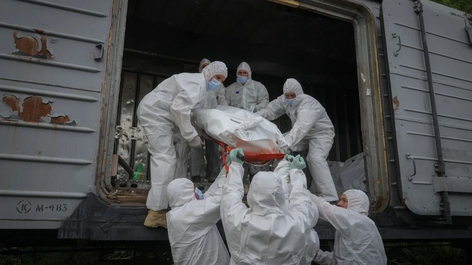 Ukraińscy żołnierze ładują ciała zabitych Rosjan do wagonu chłodni. Kijów, 13 maja 2022 roku