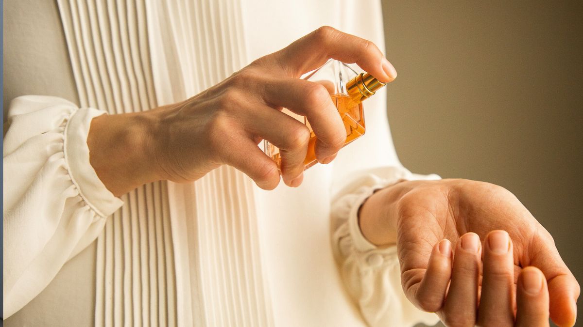 Kobieta aplikuje perfumy na nadgarstek