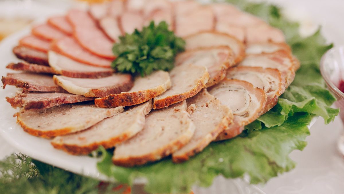 Pokrojone wędliny na półmisku przyozdobione sałatą