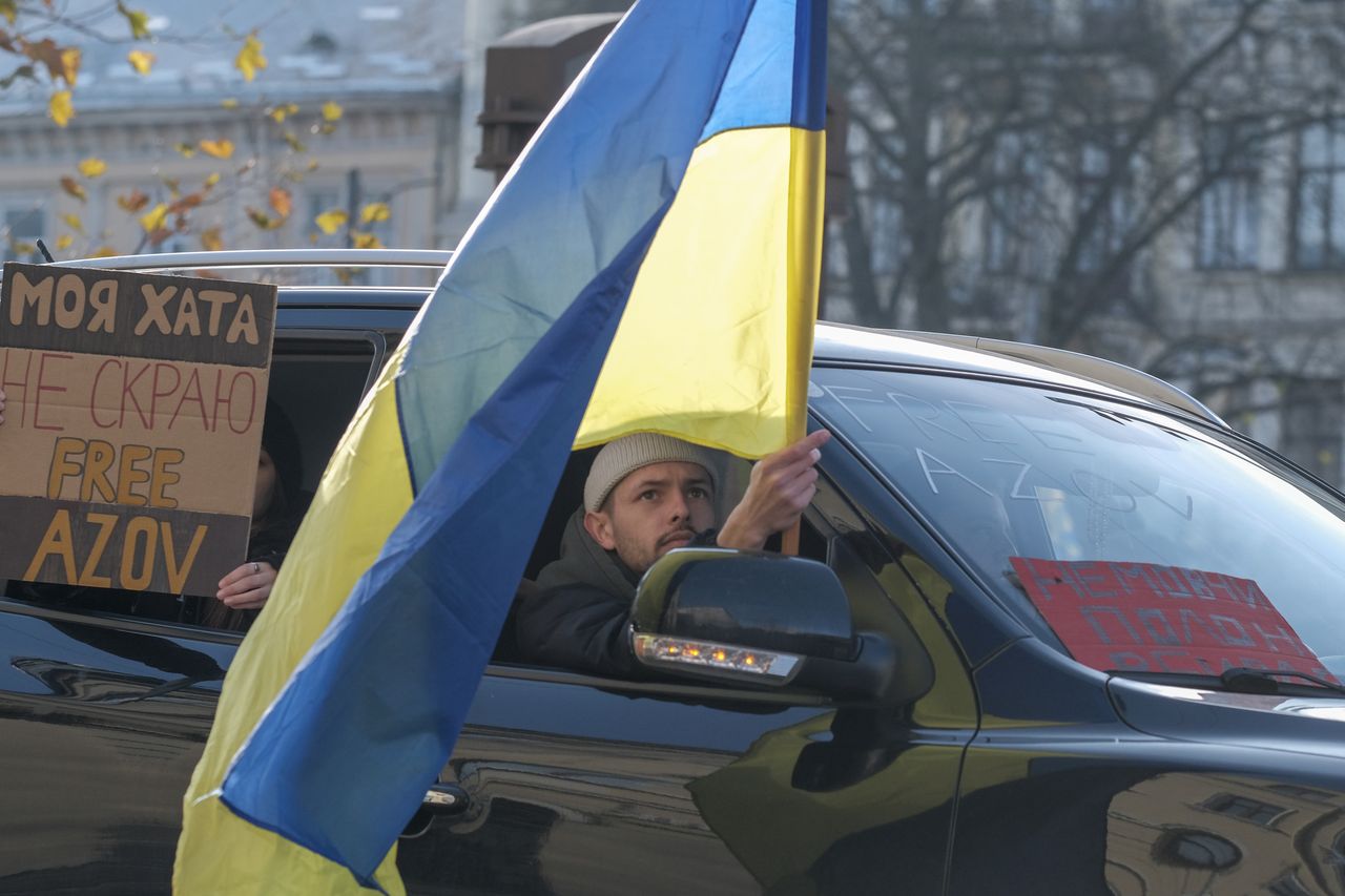 LVIV, UKRAINE - DECEMBER 1: An activist from a car holds Ukrainian flag urging for the return of Ukrainian soldiers of Mariupol garrison from Russian captivity during the rally organized near the Lviv Theatre of Opera and Ballet on December 1, 2024 in Lviv, Ukraine. The Free Azov rally in support of the captured defenders of Mariupol regularly takes place in Lviv and other Ukrainian cities. The participants - activists and relatives of the POWs come out to remind people about the Ukrainian soldiers who have been held in Russian captivity since 2022. (Photo by Les Kasyanov/Global Images Ukraine via Getty Images)