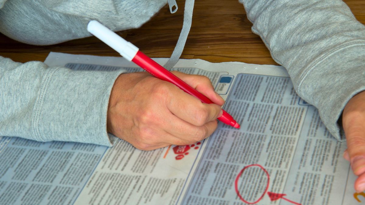 Mężczyzna zakreśla ogłoszenia