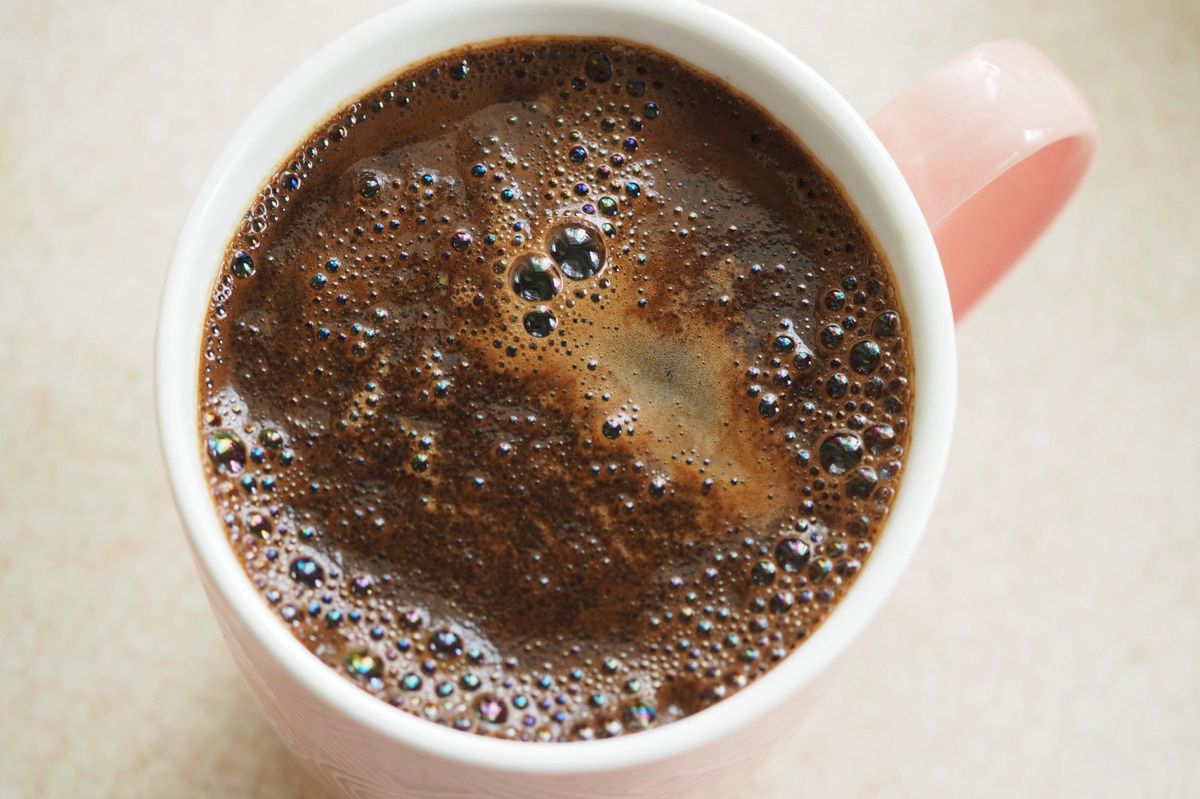 Coffee with froth in a pink mug