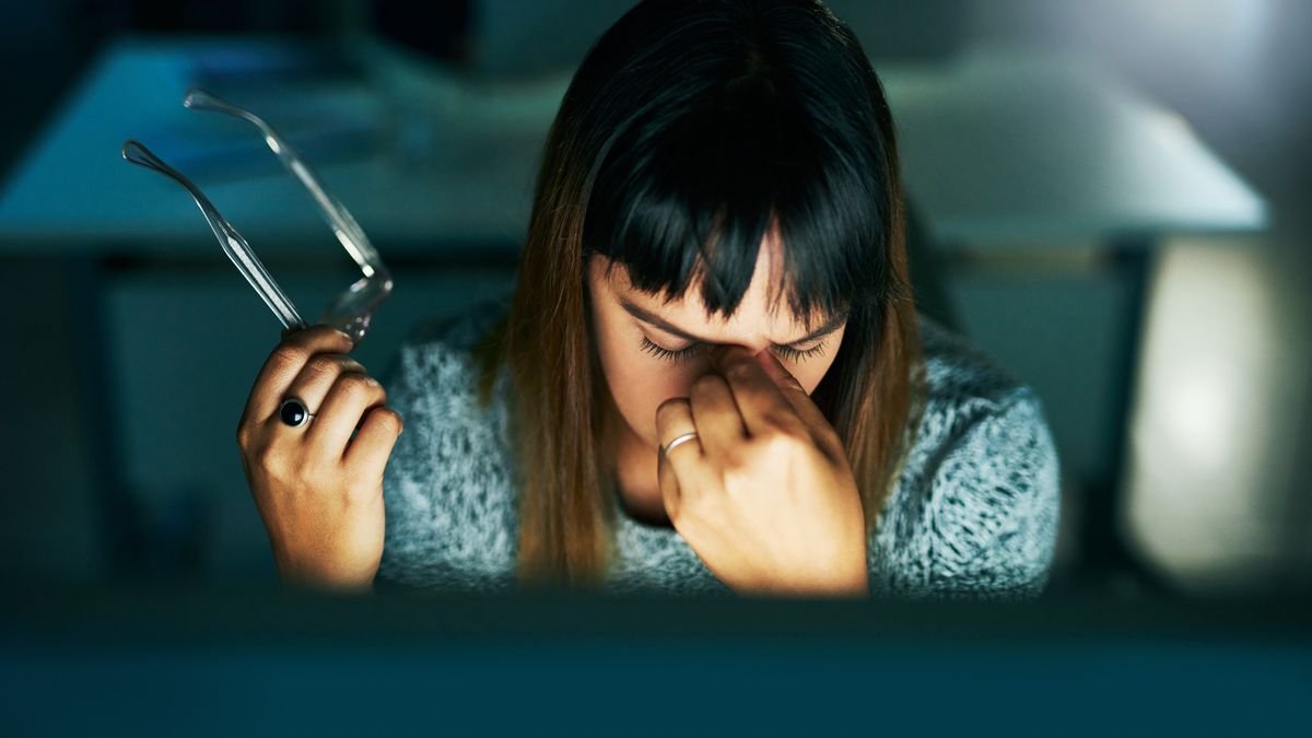 Late nights can be stressfulHigh angle shot of an attractive young businesswoman looking stressed while working on her computer late at night in the officeMoyo Studio